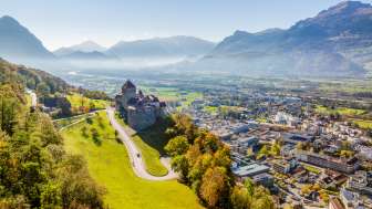 Veduta aerea del castello di Vaduz con vista sulla città di Vaduz e sulla valle del Reno in una limpida giornata autunnale