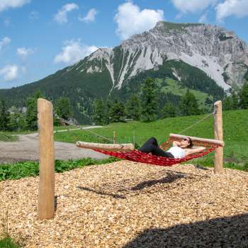 Una donna è sdraiata in relax su un'amaca lungo il sentiero delle altalene