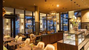 Elegante caffetteria con accoglienti aree salotto, arredi in stile e un'atmosfera di luce calda