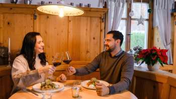 Coppia a cena nell'accogliente salottino in legno del Gasthof Au