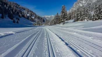 Pista da sci di fondo appena battuta a Steg con vista panoramica sul paesaggio alpino innevato
