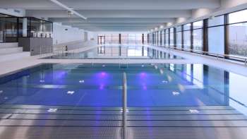 Moderna piscina coperta a Triesen con vasca illuminata e ampia vetrata.