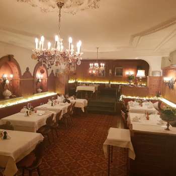 Lunga sala da pranzo con tavoli elegantemente apparecchiati e illuminazione d'atmosfera