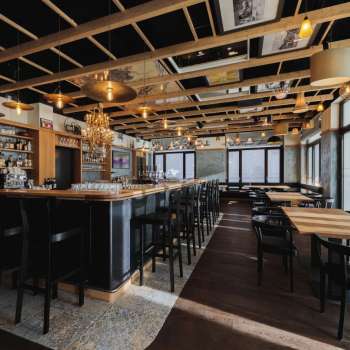 Interno luminoso del St. Martins Pub con bar, mobili in legno e grandi finestre.