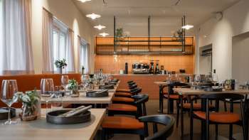 Ristorante moderno con zona cucina a vista e tavoli elegantemente apparecchiati Ristorante moderno con zona cucina a vista e tavoli elegantemente apparecchiati