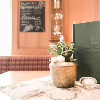 Primo piano di una tavola imbandita con carte da menu, fiori e decorazioni rustiche