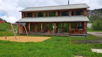 Esterno del Malbipark-Bistro con parco giochi e prato in primo piano