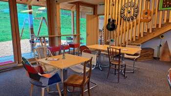 Accogliente sala da pranzo con elementi in legno - La sala da pranzo è progettata con mobili in legno chiaro e chitarre decorative alle pareti, atmosfera calda grazie alla luce naturale.