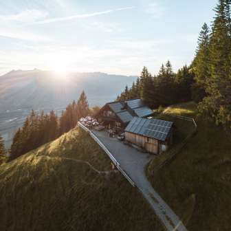 Ripresa panoramica di una remota baita di montagna nel Liechtenstein con vista sulla valle del Reno e tecnologia solare sul tetto