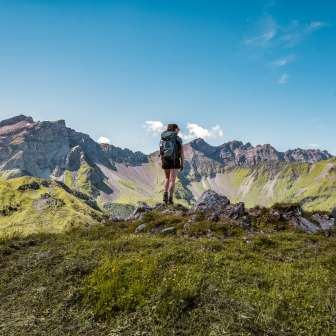 Escursionista su una vetta del Liechtenstein con vista su un'imponente catena montuosa - estate, libertà e natura pura