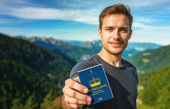 «Pass attrazioni TUTTO INCLUSO» Uomo mostra il «Pass attrazioni TUTTO INCLUSO» con panorama montano sullo sfondo