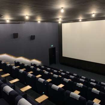 lice del grande schermo cinematografico dello Skino Schaan, con file di comode poltrone dal design scuro.